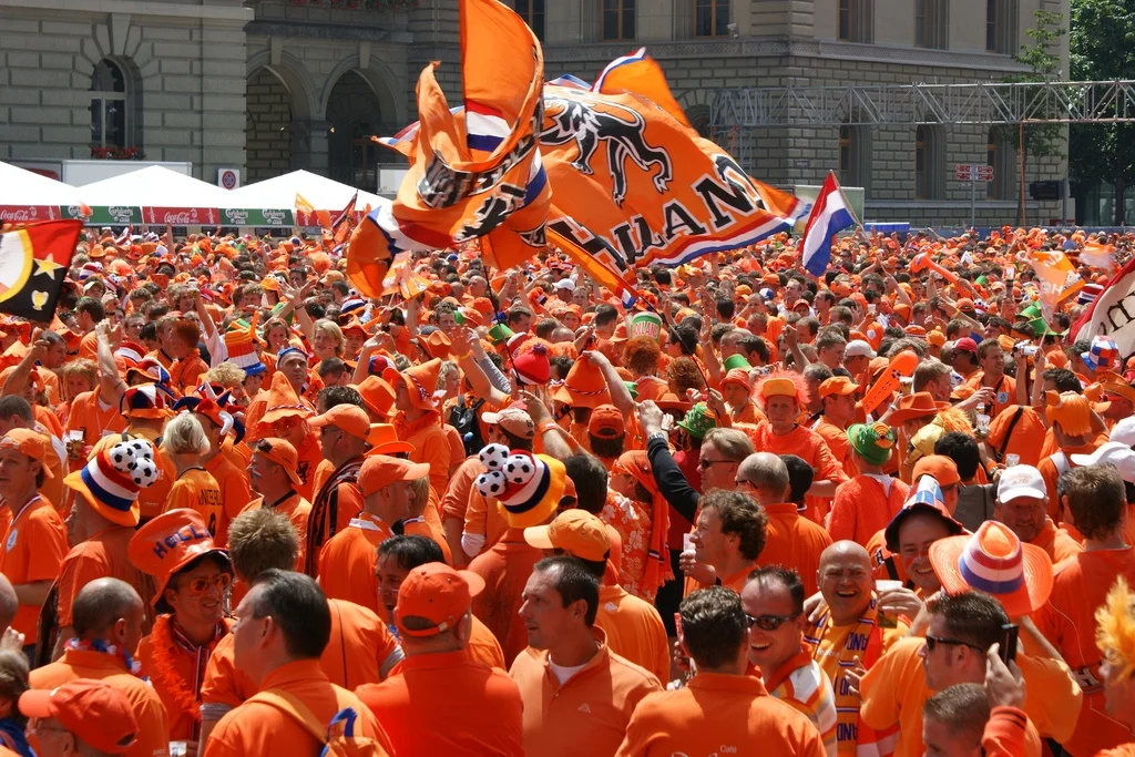 Huge crowd dressed in orange celebrating King’s Day 2025 in Amsterdam with flags and music