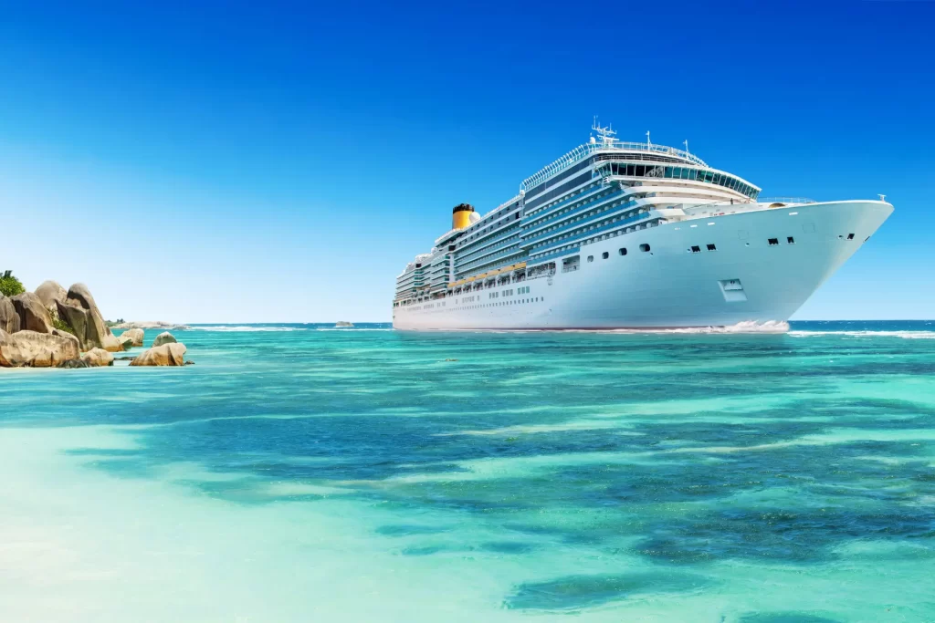 Luxury cruise ship sailing through clear turquoise waters on a cruise around the world