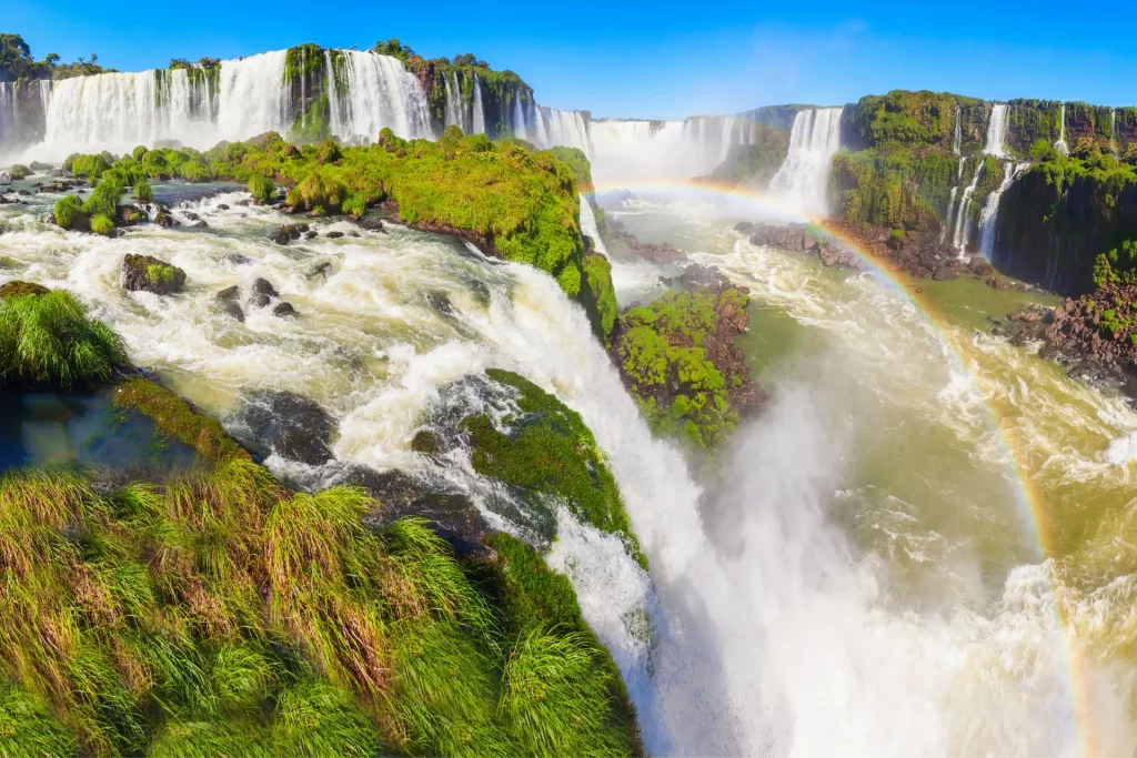 Panoramic view of Iguassu Falls with rainbow and lush greenery in Foz do Iguaçu, Brazil 2025