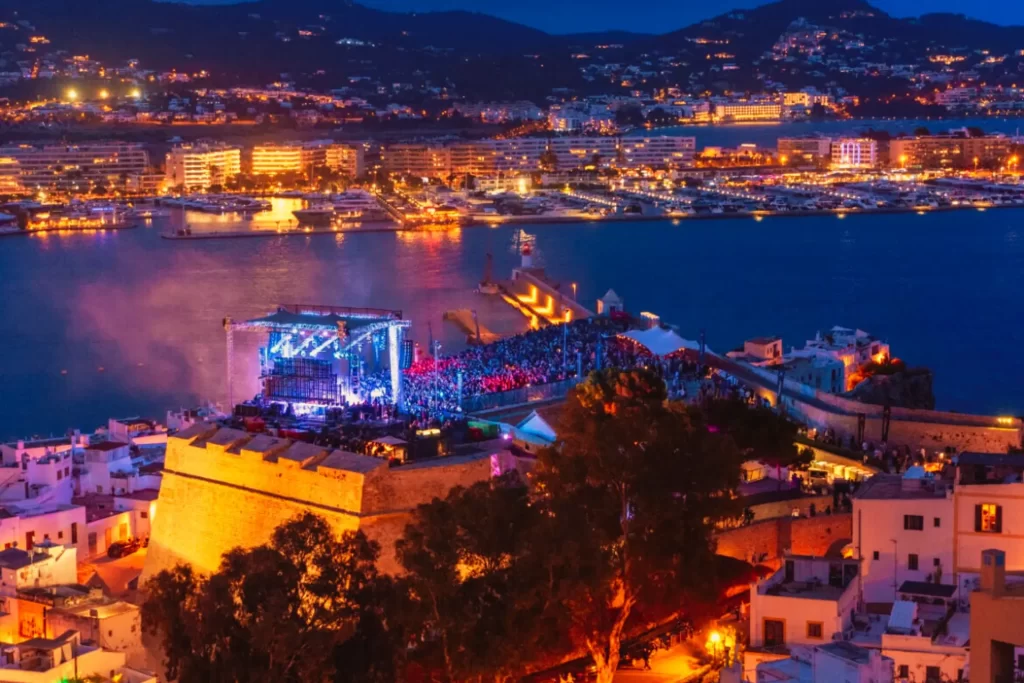 Aerial night view of IMS Ibiza 2025 at Dalt Vila with stage lights and crowd
