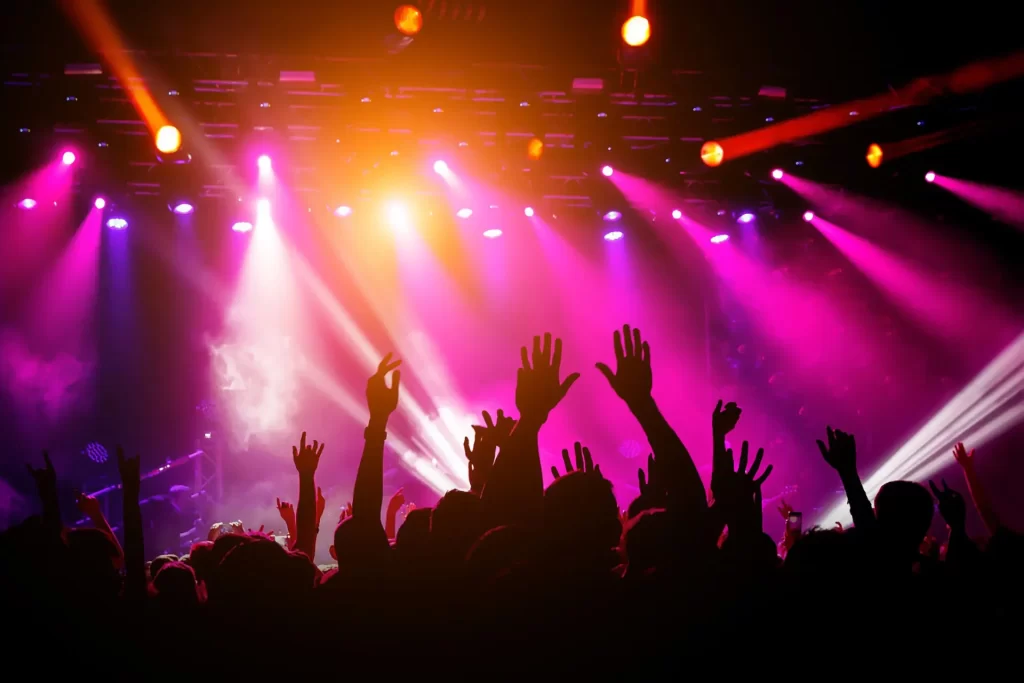 Crowd dancing under colorful lights at a club during Ibiza opening week