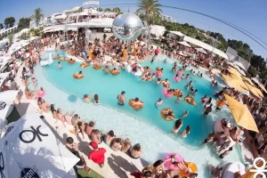 Pool party at O Beach Ibiza during summer 2025 with a vibrant crowd and DJs by the pool.