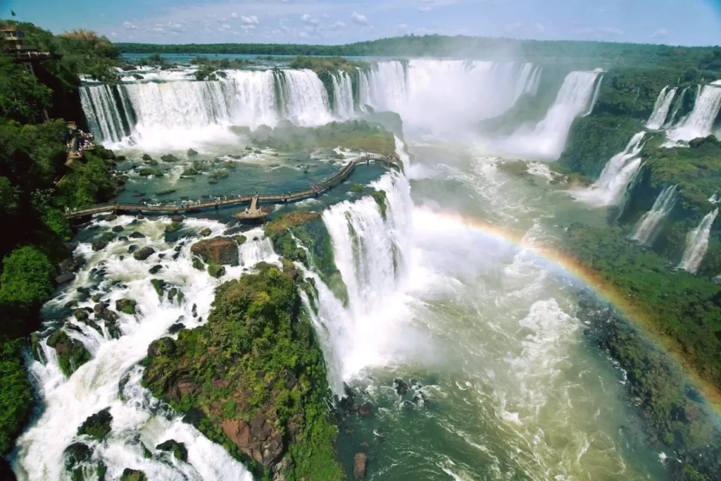 Panoramic view of Iguassu Falls from the Brazilian side with a rainbow and observation walkway – one of the top tours in Foz do Iguaçu.