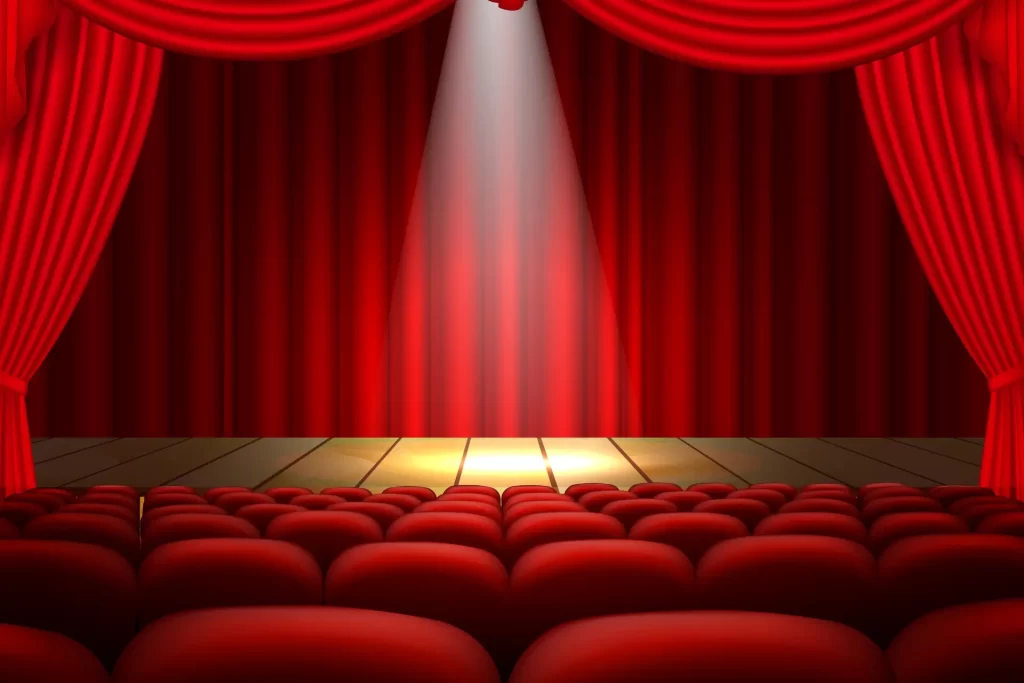 Empty theater stage with red curtains and spotlight for 2025 live performances in the USA