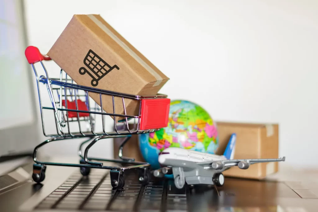 Shopping cart with travel box, airplane, and globe – representing Amazon Travel Essentials